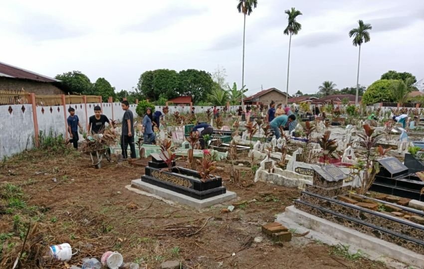 Bhabinkamtibmas Polsek Siantar Marihat Gotong Royong Bersama Warga Bersihkan TPU